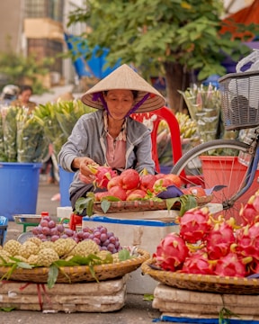 a woman selling fruits at an outdoor market