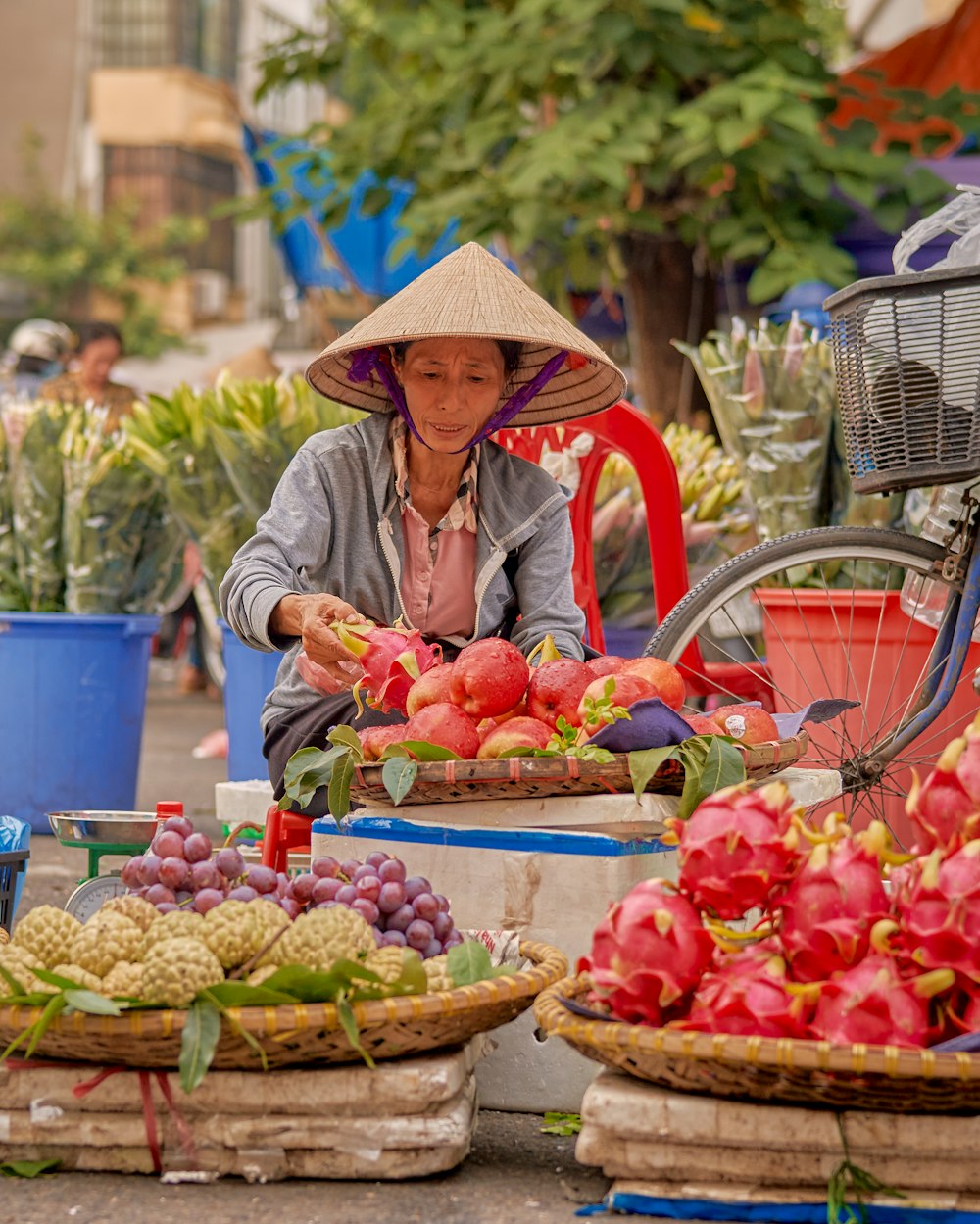 a woman selling fruits at an outdoor market