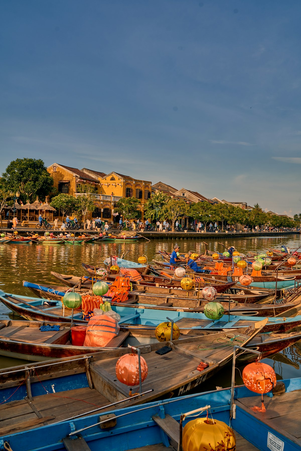 Hoi An harbour near An Bang — traditional wooden fishing boats moored on calm water in the early morning light