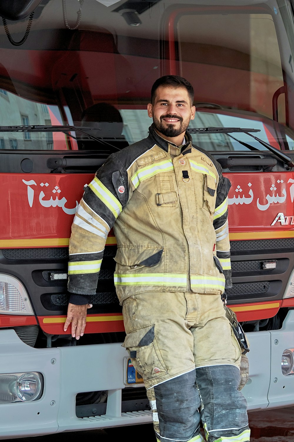 a man in a firefighter uniform standing in front of a fire truck