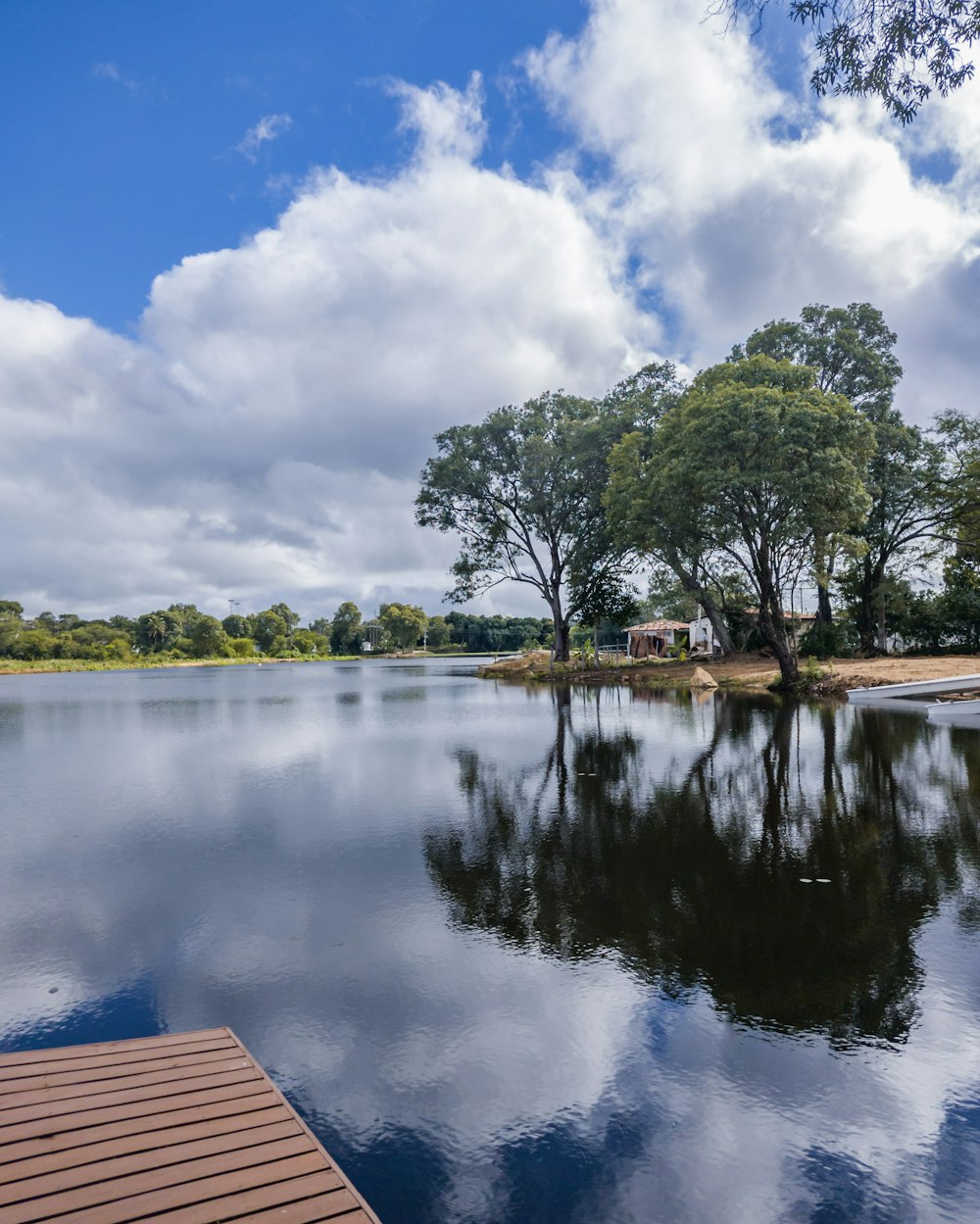 a body of water with trees and a house in the background