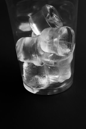 An elegant block of clear ice cubes stacked neatly beside a cocktail setup.