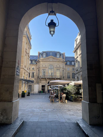European university courtyard with historic architecture and students enjoying a coffee break.