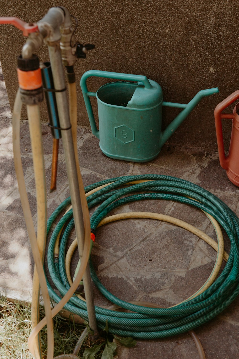 a green hose attached to a green pipe