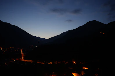 Evening shot of the mountain suite lit softly against a backdrop of twilight hills.