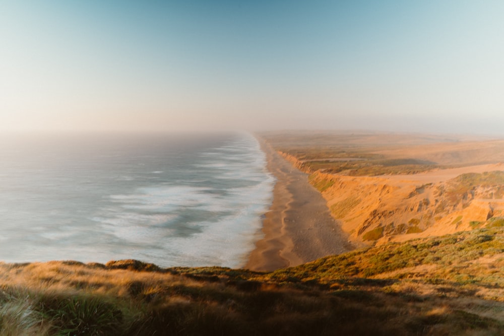 a sandy beach with a body of water in the background