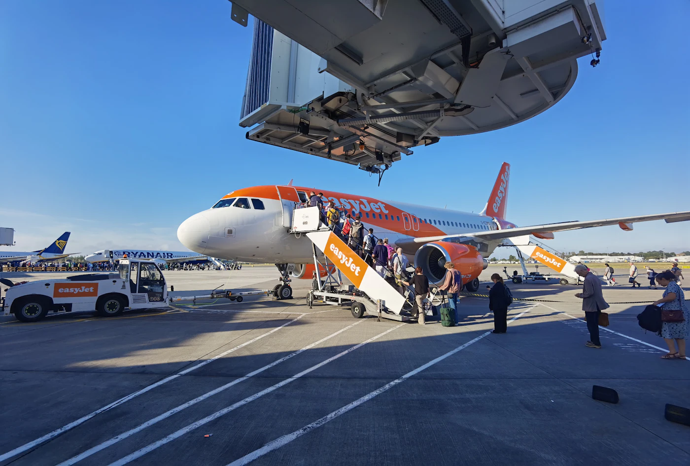 Pasajeros embarcando por escalerilla en un avión de bajo coste en la pista de un aeropuerto