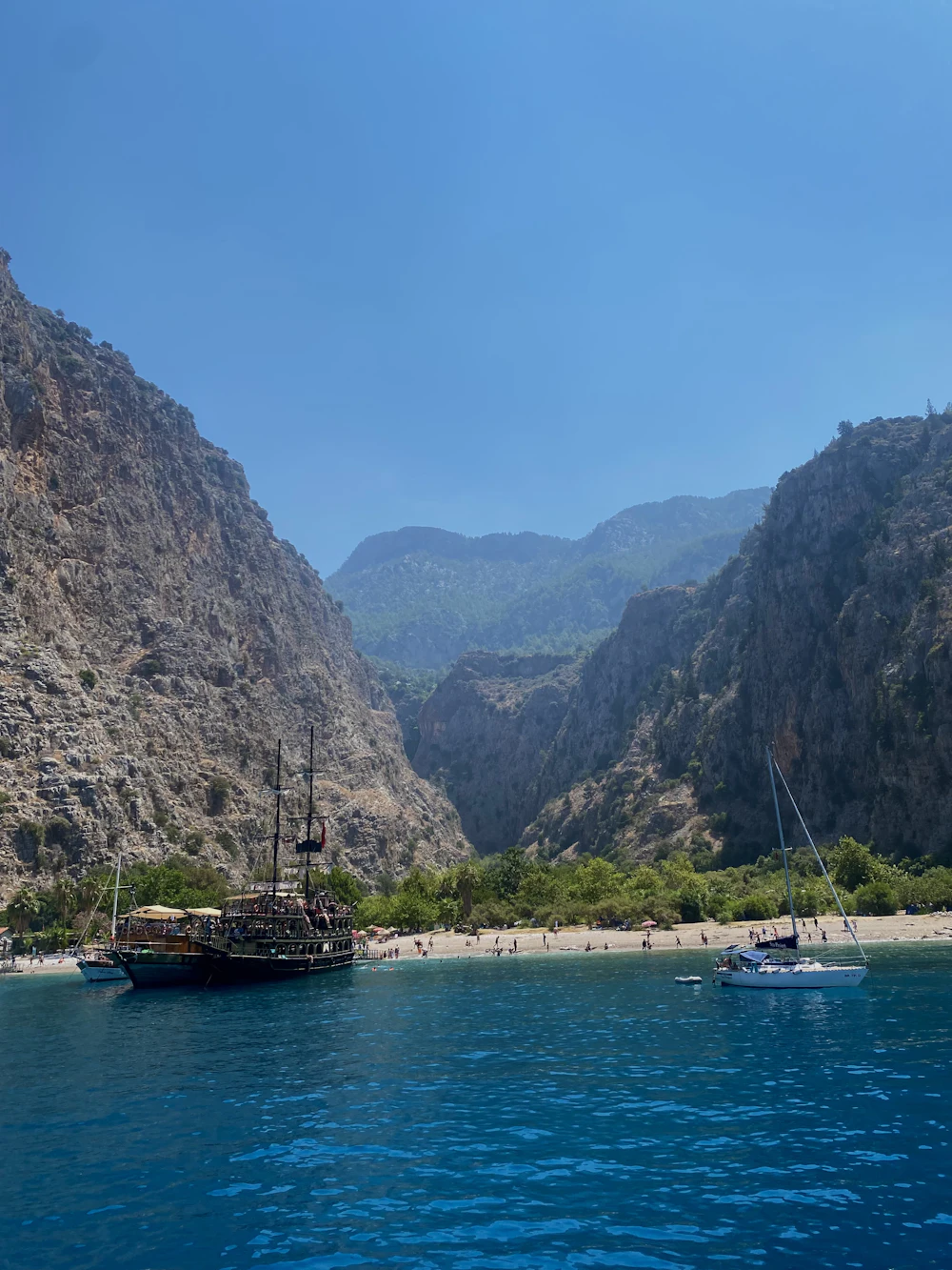 Gulets und Segelboote in einer Bucht mit steilen Bergen, Ölüdeniz