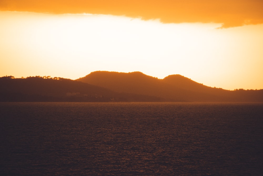 a body of water with hills in the background