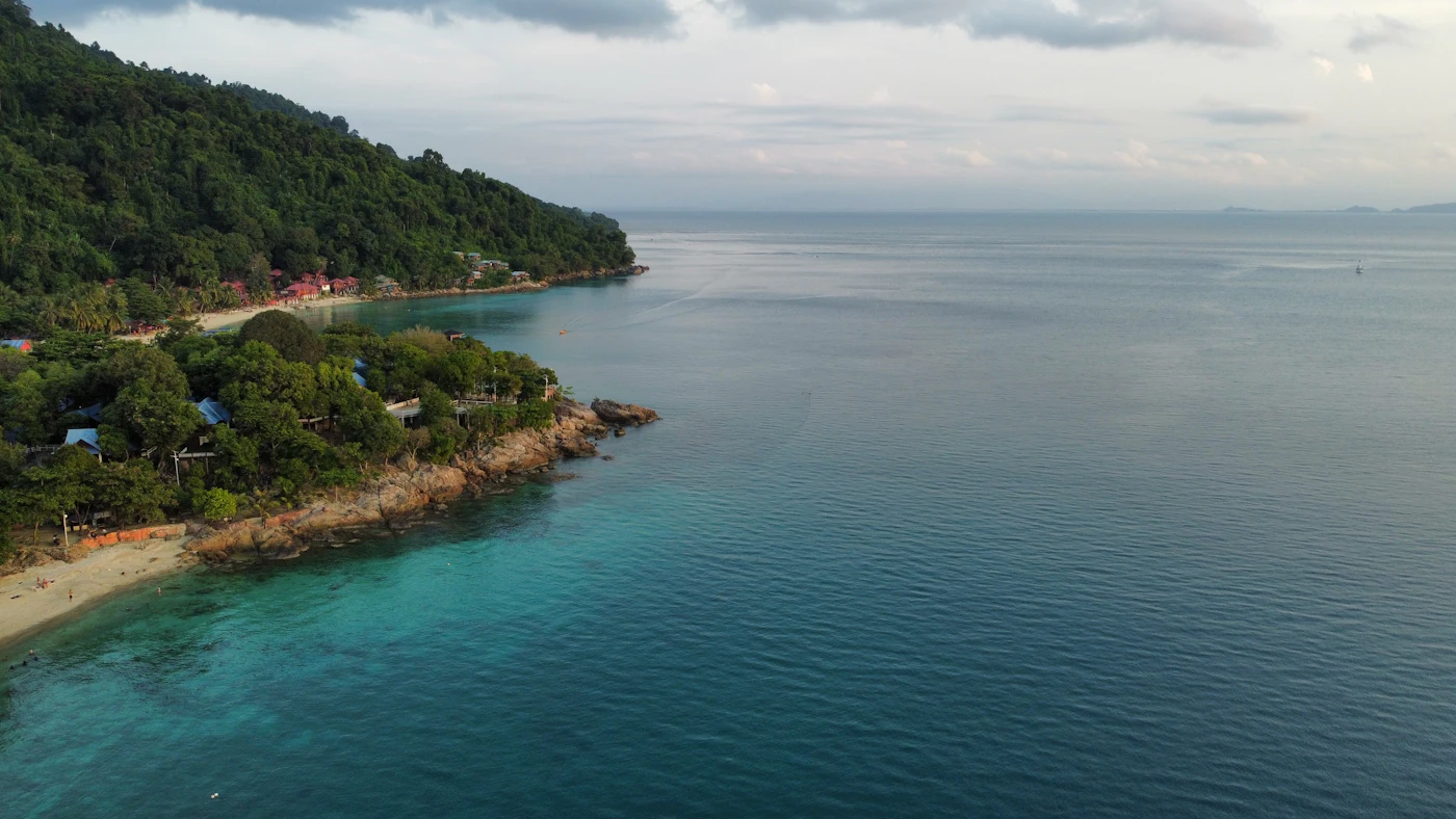 Forested headland and calm clear sea at Perhentian Kecil, Malaysia