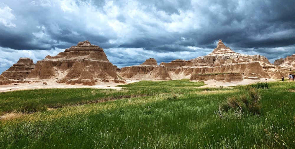 a grassy field with a group of large pyramids in the background