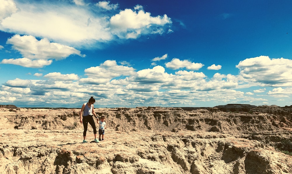 a person and a child walking on a rocky terrain