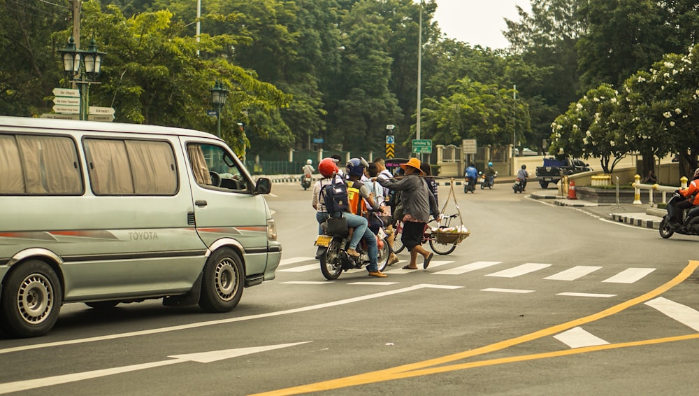 a group of people ride on a motorcycle down a street
