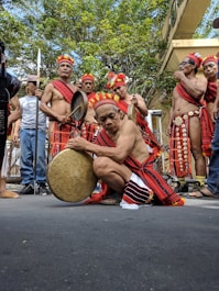 a group of Filipino men playing instruments; an Elder playing the Gansa