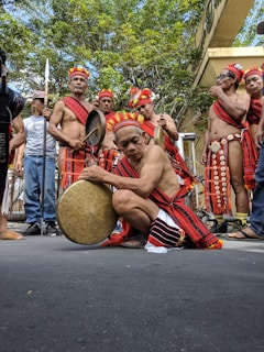 a group of Filipino men playing instruments; an Elder playing the Gansa
