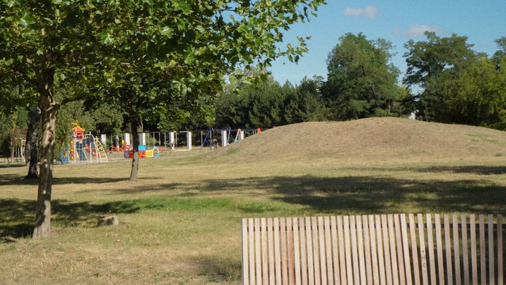 a grassy area with trees and a fence around it