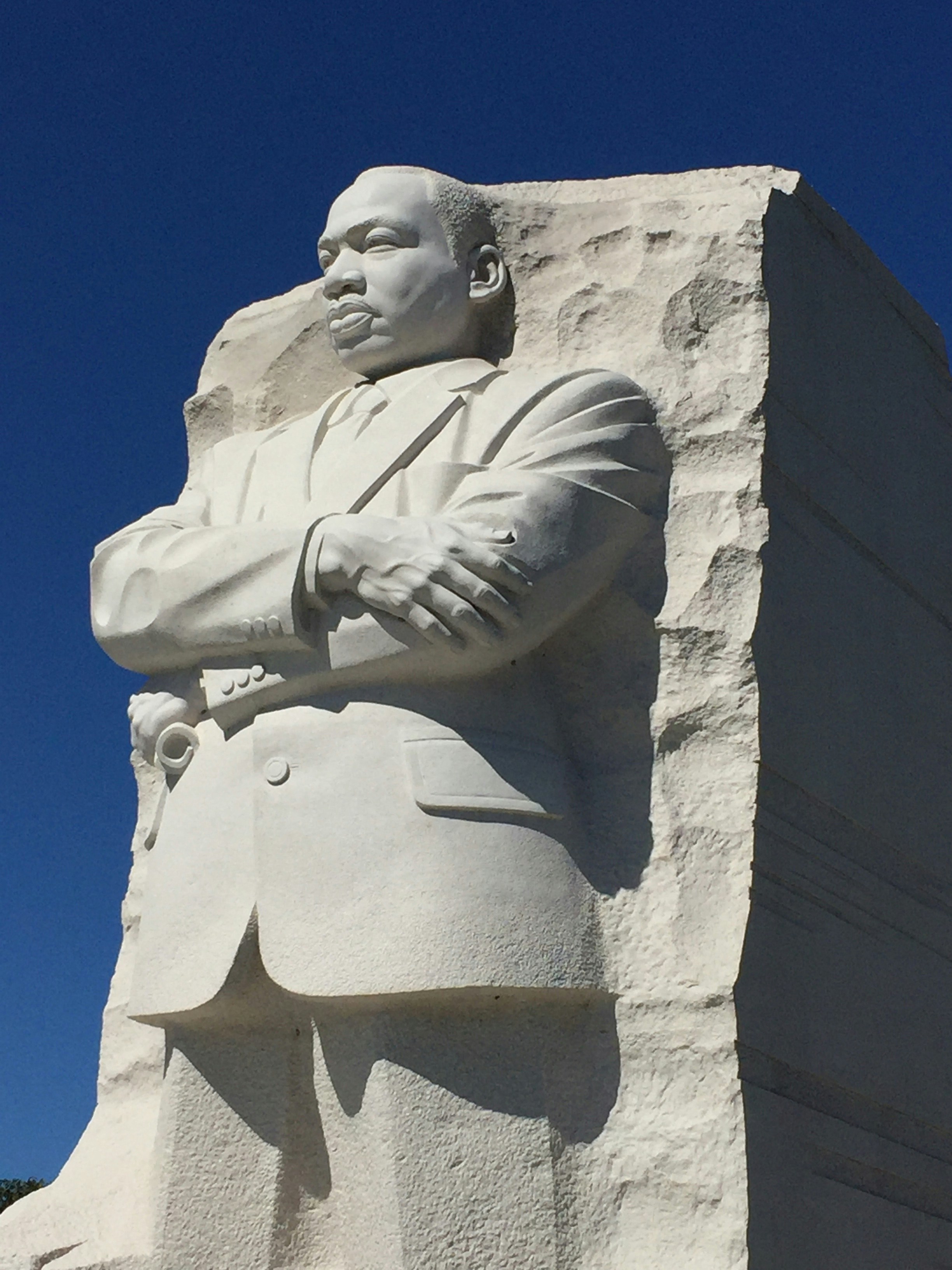 a statue of a person holding a sword with Martin Luther King Jr. Memorial in the background