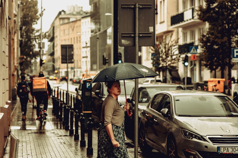 a person holding an umbrella on a sidewalk
