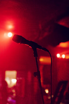 A warm radio studio with a microphone and headphones, softly lit to evoke a peaceful atmosphere.