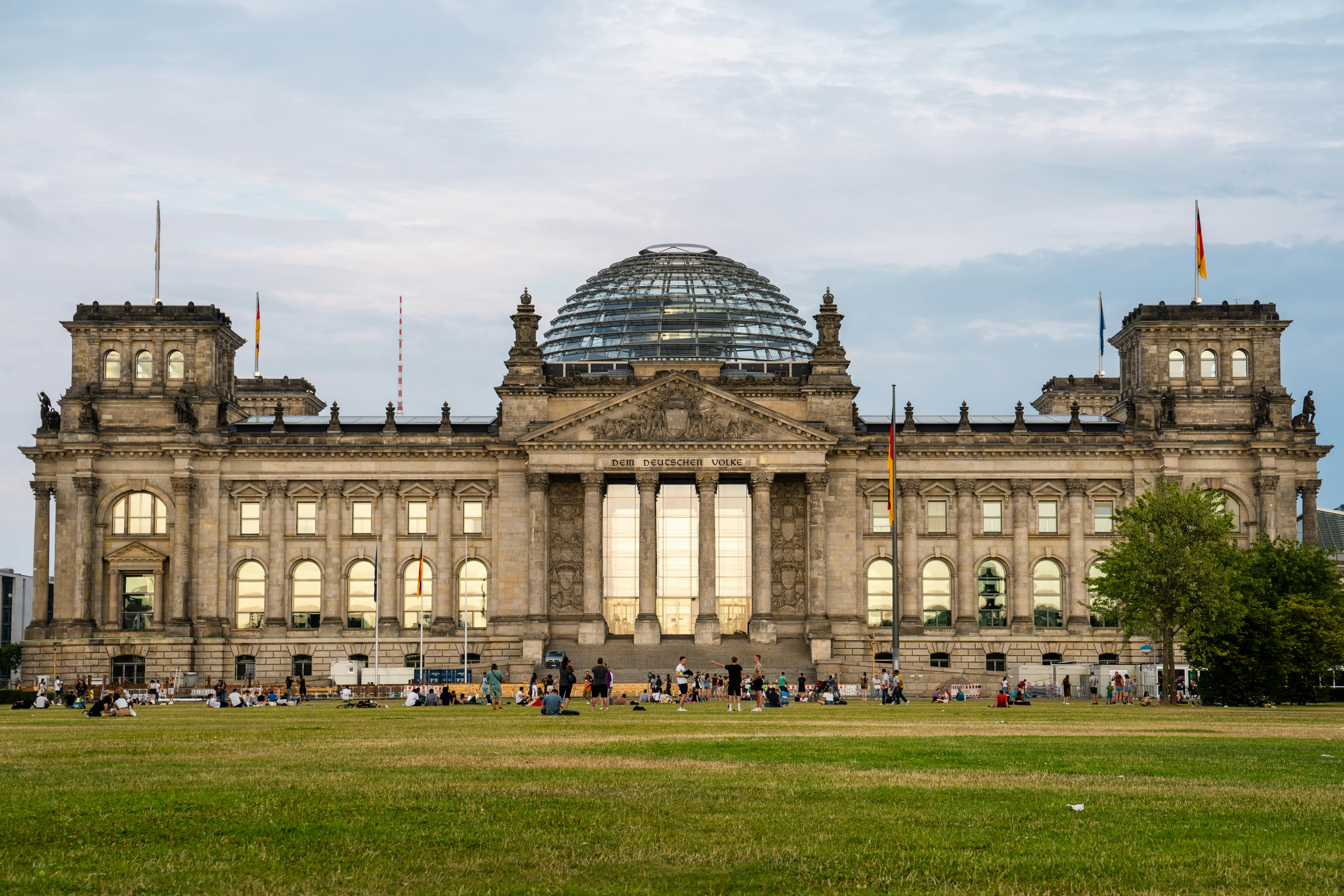 a large building with a dome roof with Reichstag building in the background
