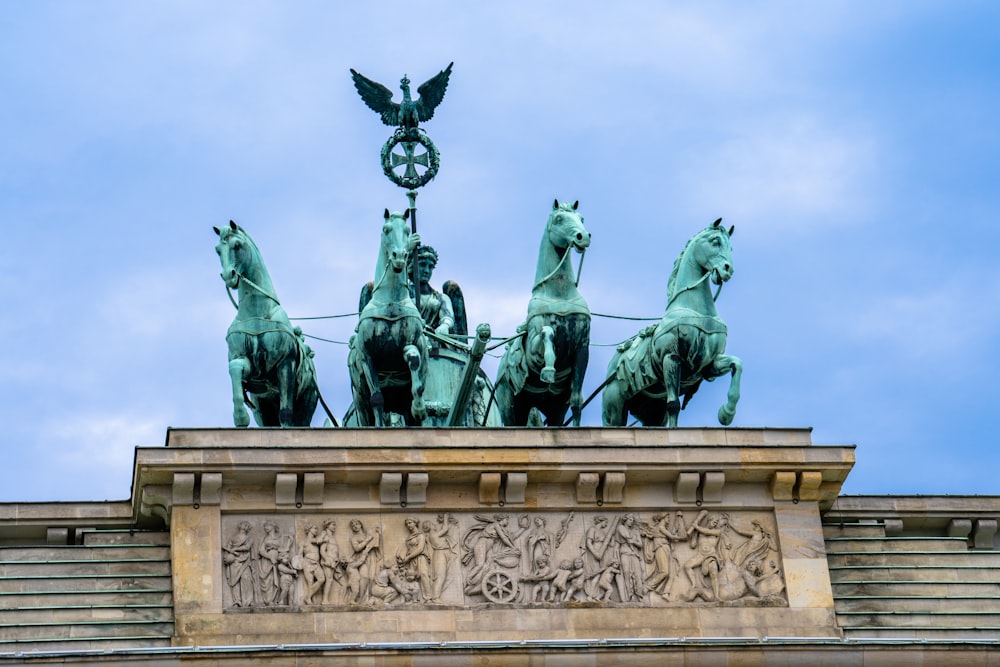 a statue of a group of people with Brandenburg Gate in the background