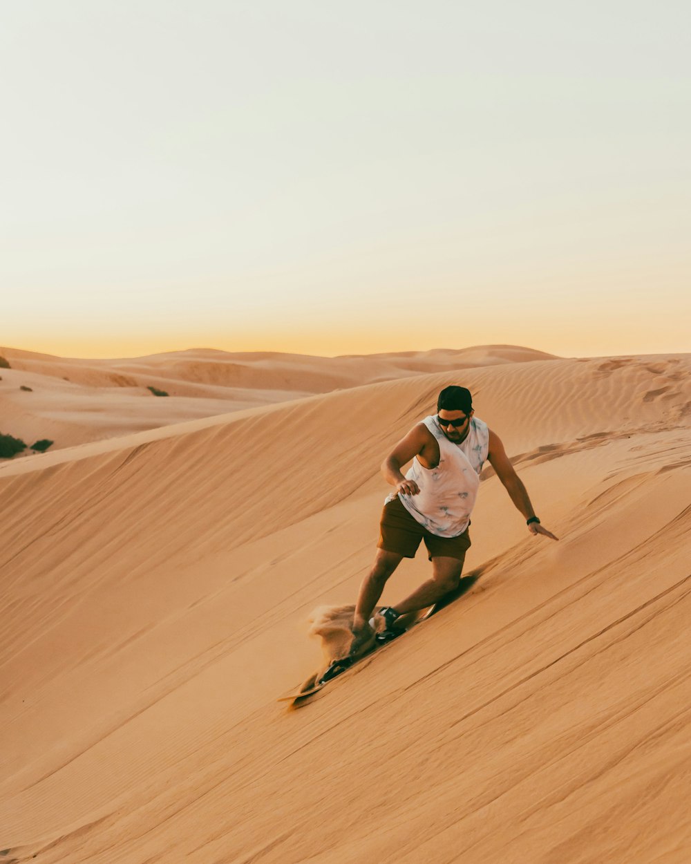 Un hombre esquiando por una duna de arena