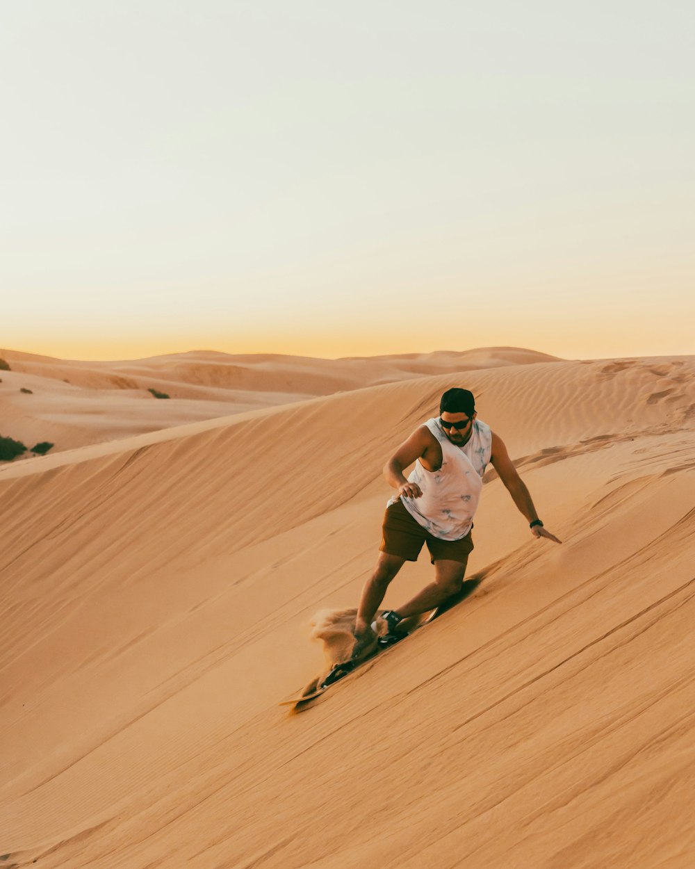 um homem esquiando por uma duna de areia