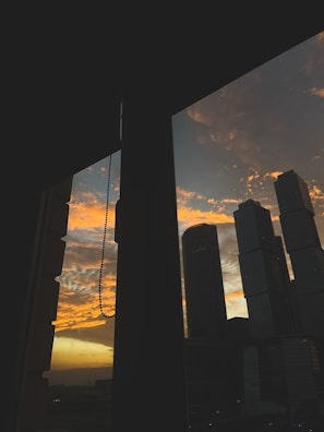 City skyline viewed from a high-rise office window at sunset.