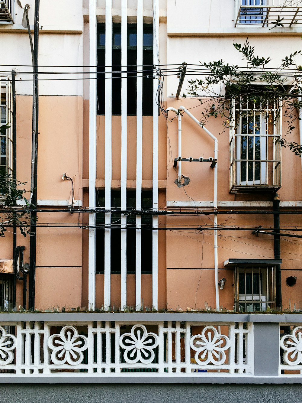 un edificio con una valla y un árbol en el frente