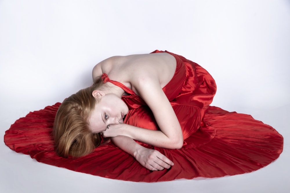 a person lying on a red blanket