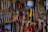 A rustic workshop wall is covered with neatly arranged tools, including wrenches, pliers, screwdrivers, and saws. A small calendar hangs on the wall, adding to the organized chaos. The tools vary in color and size, indicating their different uses.