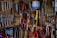 A rustic workshop wall is covered with neatly arranged tools, including wrenches, pliers, screwdrivers, and saws. A small calendar hangs on the wall, adding to the organized chaos. The tools vary in color and size, indicating their different uses.