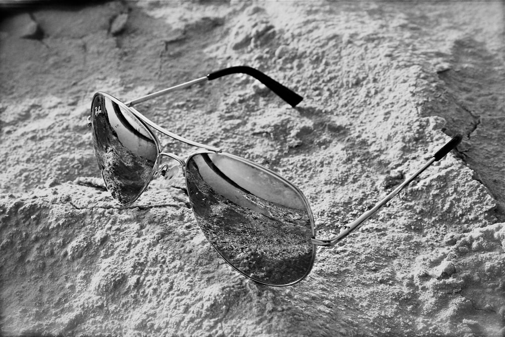 a pair of sunglasses on a stone surface