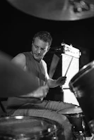 Drummer caught mid-beat with intense focus and sweat visible