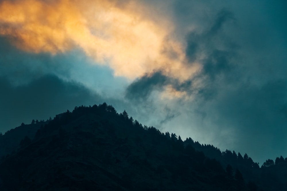 a mountain with clouds above it