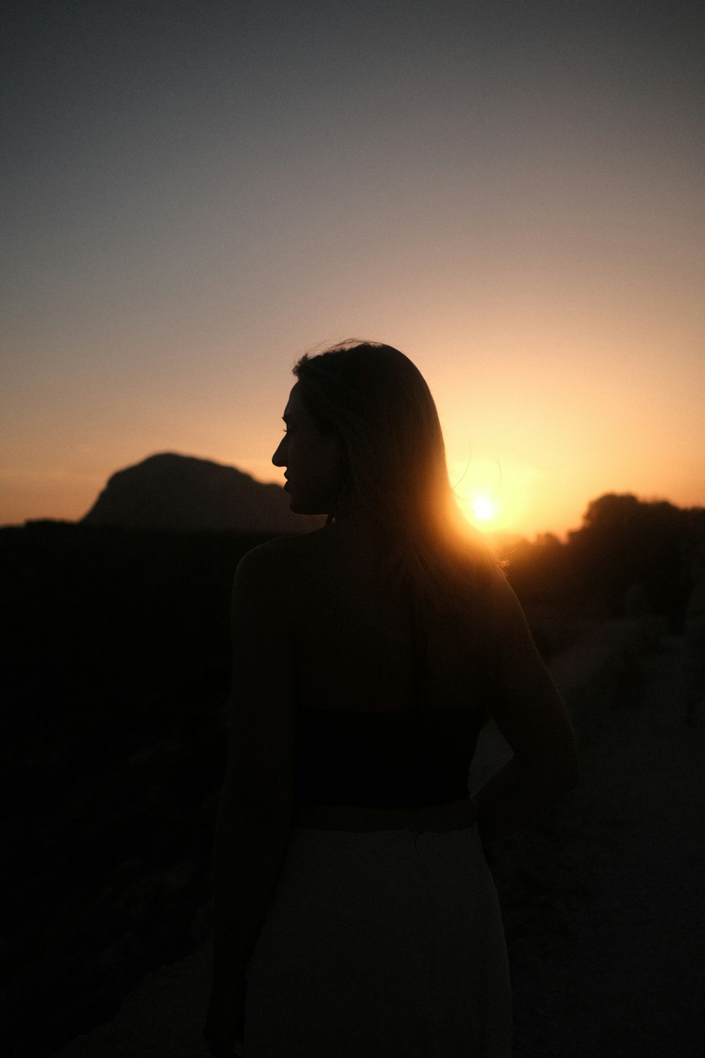 a person standing in front of a sunset