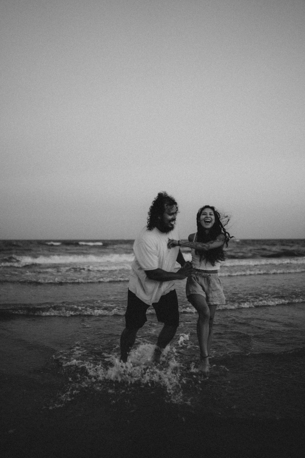 a man and woman running on a beach