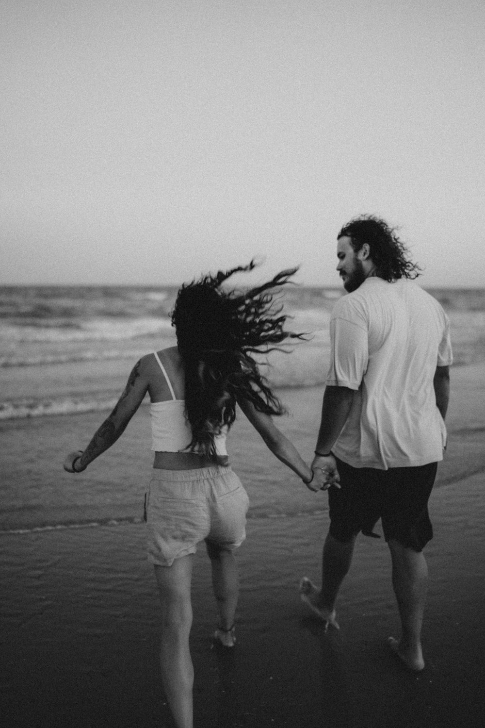 a man and woman walking on a beach