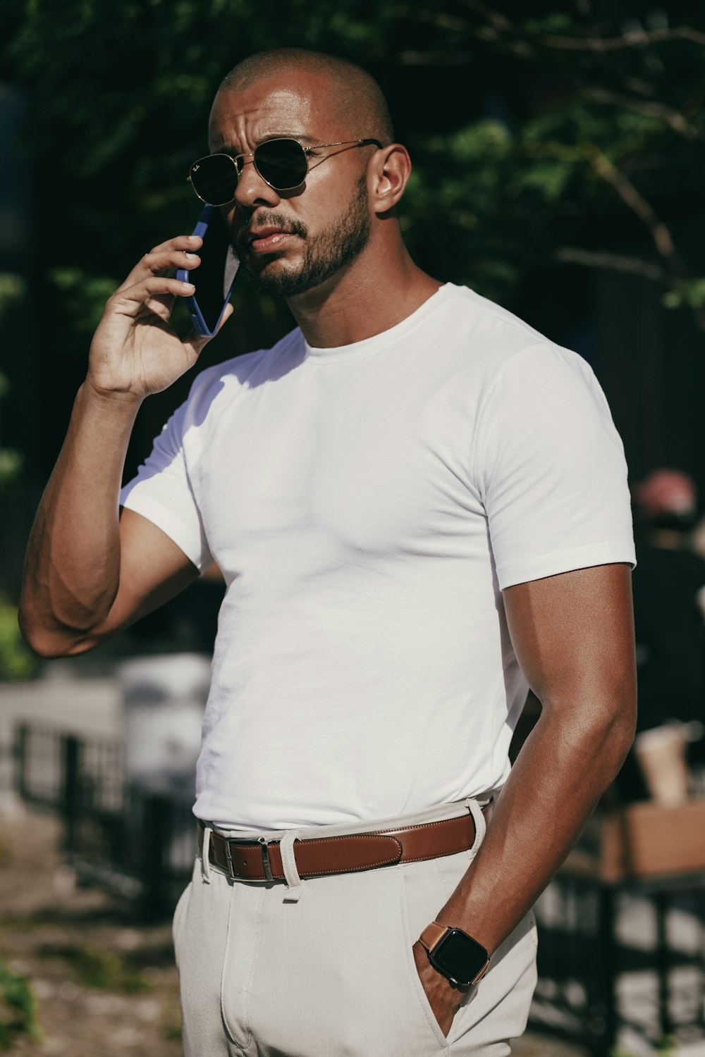 Un hombre con gafas de sol y sosteniendo un teléfono