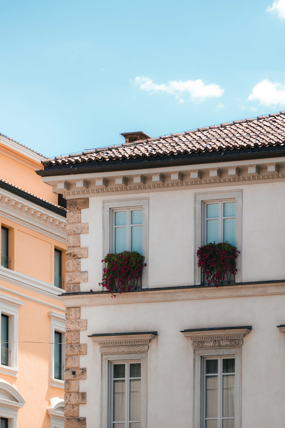 a building with a roof and flowers on the windows