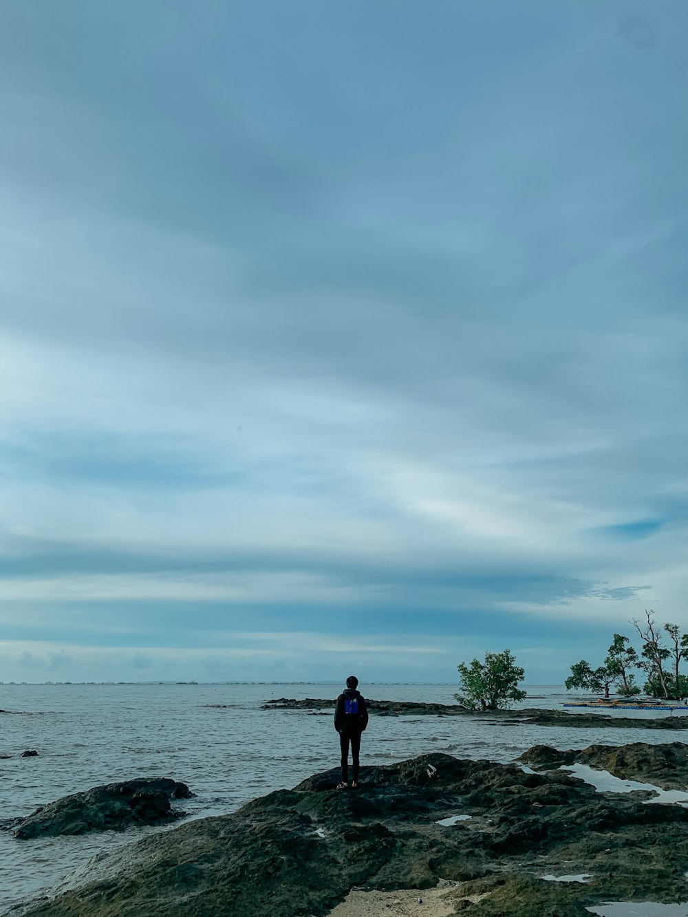 a person standing on a rocky beach