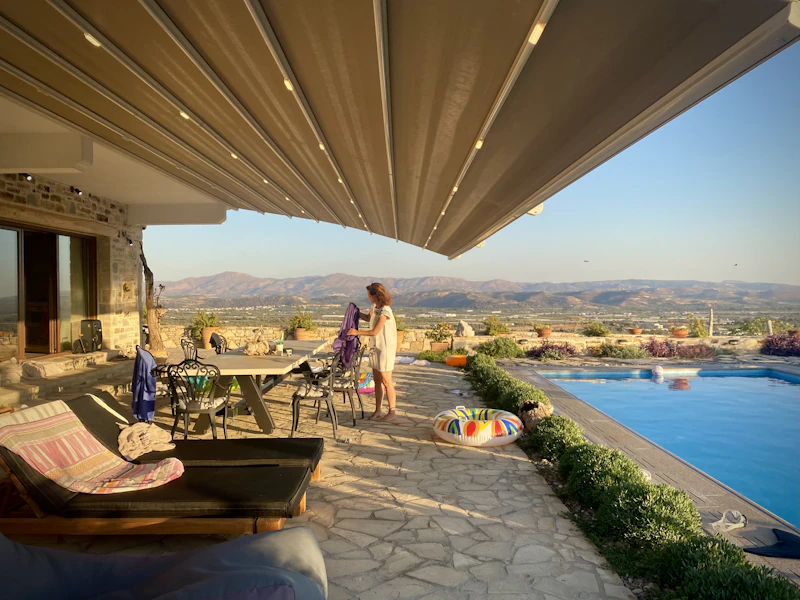 Retractable patio awning over a deck with a pool view