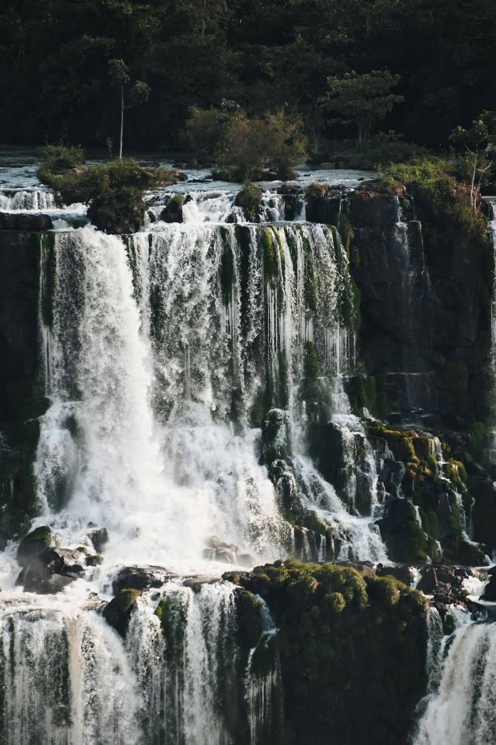 a waterfall with rocks and trees