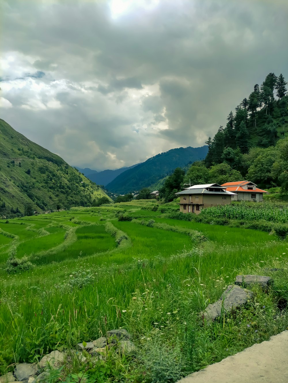 a house in a valley with mountains in the background