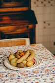 A bright yellow stoneware plate filled with fresh fruit, set against a warm linen tablecloth.