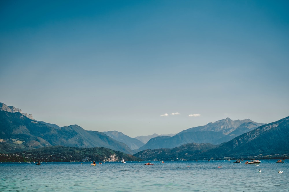 a body of water with boats and mountains in the background