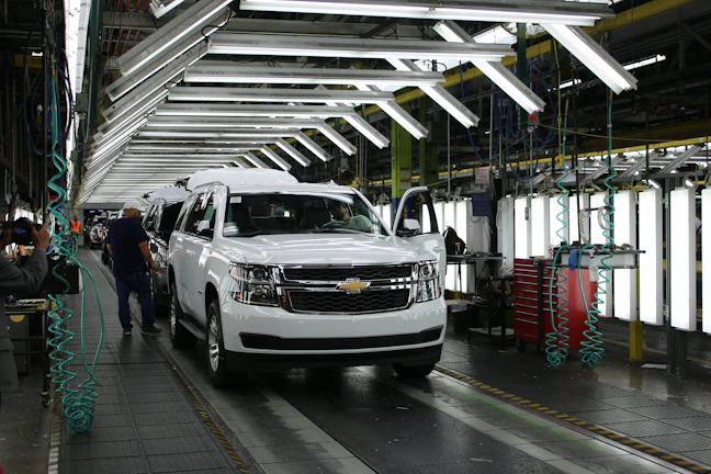 A group of production workers assembling automotive parts in a bright factory in Slovakia.