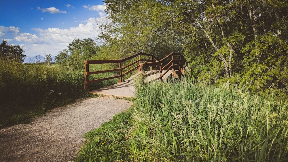 uma ponte de madeira sobre uma estrada de terra