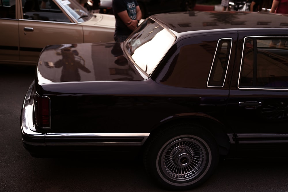 a black car with a person standing in the back