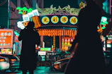 A bustling futuristic street market scene bathed in atmospheric fog and flickering neon signs.